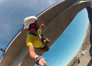 Joven saltando desde el puente de Tenoya, disfrutando de la adrenalina del puenting mientras cae libremente hacia el precipicio rodeado de barrancos.